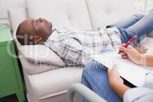 Man lying on sofa talking to his therapist