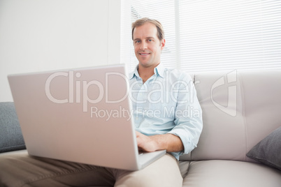 Casual man using laptop on the couch