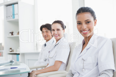 Smiling doctors sitting beside each other