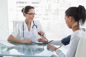 Doctor taking patients blood pressure