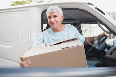 Man with carton box in front of van