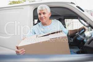 Man with carton box in front of van