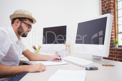 Casual designer drawing at his desk