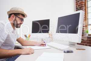 Casual designer drawing at his desk