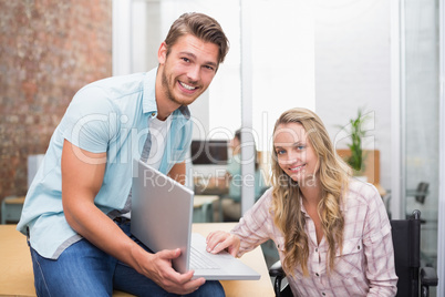 Business people smiling and working together with a laptop