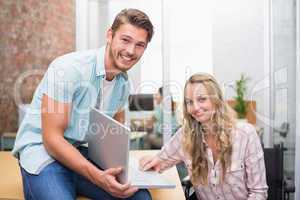 Business people smiling and working together with a laptop