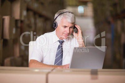 Warehouse manager using laptop