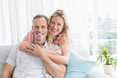 Content woman hugging his husband on the couch