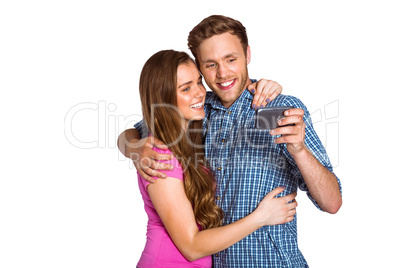 Cheerful young couple taking selfie with smart phone