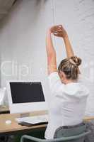 Businesswoman stretching hands in front of computer