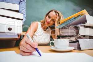 Beautiful businesswoman writing document at desk