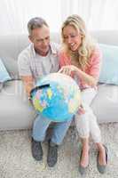 Happy couple looking at a globe