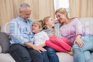 Happy parents with their children on sofa