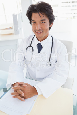 Smiling doctor sitting at his desk