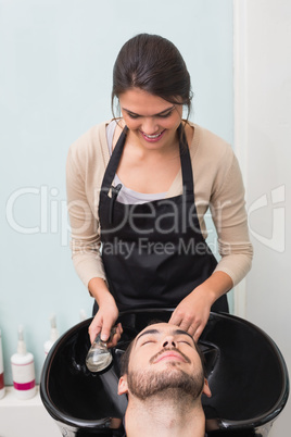 Hair stylist washing mans hair