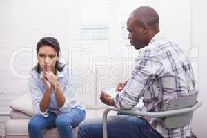 Serious therapist listening to his talking patient