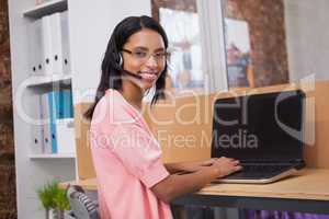 Creative woman with headset using computer at desk