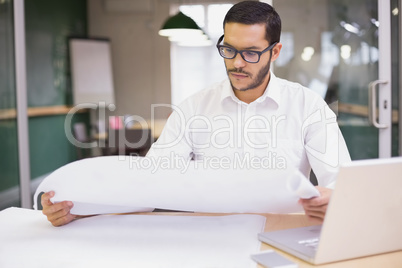 Casual architect studying his blueprints