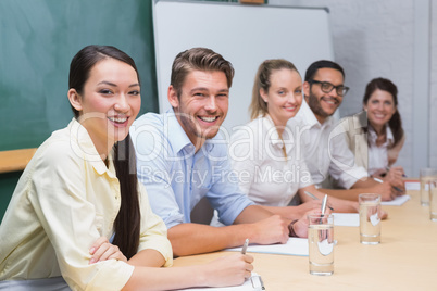 Smiling business people taking notes at a presentation