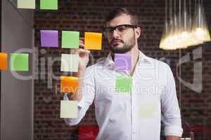 Casual businessman writing on sticky notes