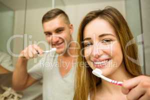 Cute couple brushing their teeth