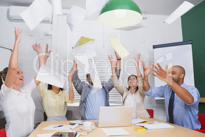 Cheerful workers throwing paper and smiling