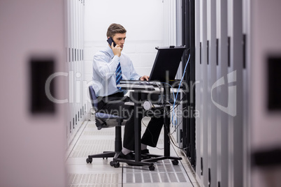 Technician talking on phone while diagnosing servers