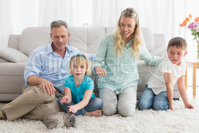 Smiling family with their rabbit on the rug