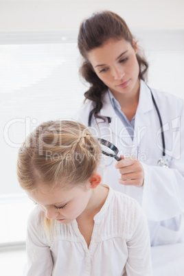 Doctor examining patient with magnifying glass