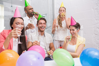 Business team celebrating with champagne and party horns