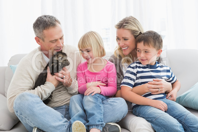 Happy family sitting with pet kitten together