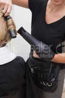 Hairdresser styling customers hair