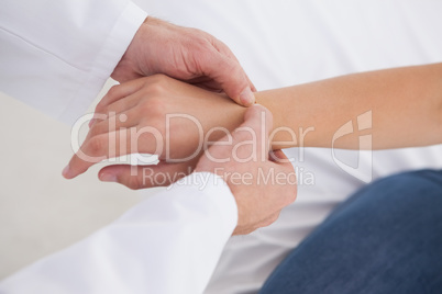 Doctor examining patients wrist