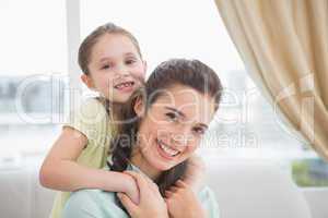 Cute mother and daughter smiling at camera