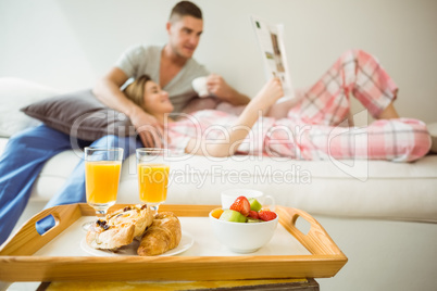Cute couple relaxing on couch at breakfast