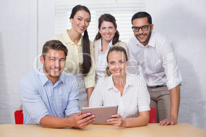 Smiling business people using digital tablet in meeting