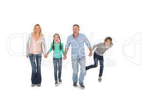 Happy family of four walking hand in hand
