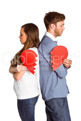 Side view of young couple holding broken heart
