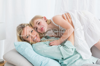 Portrait of a mother and her daughter posing on the couch