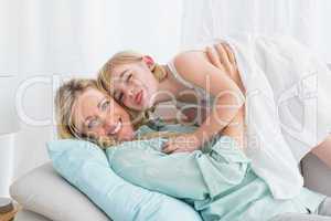 Portrait of a mother and her daughter posing on the couch