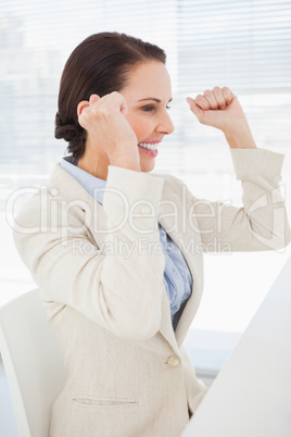 Happy businesswoman with raised arms