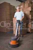 Man cleaning warehouse floor with machine