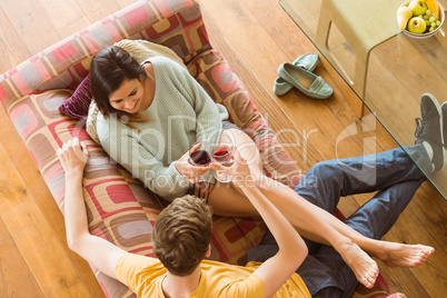 Young couple enjoying red wine on the couch