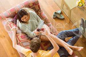 Young couple enjoying red wine on the couch