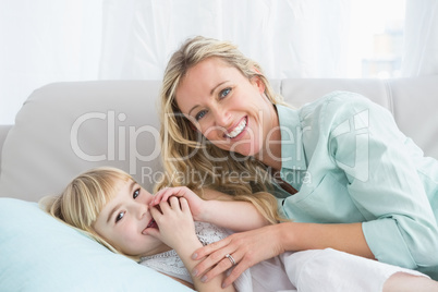 Beautiful mother and daughter lying on the couch