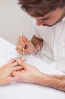 Manicurist giving customer a manicure