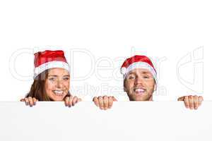 Couple in santas hats with blank board