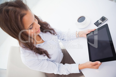 Pretty businesswoman using tablet pc at her desk