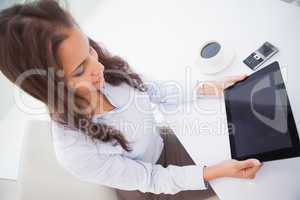 Pretty businesswoman using tablet pc at her desk