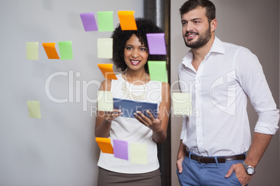 Casual business team looking at sticky notes